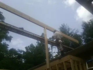 Carpenter setting a ridge beam over a new addition frame — Ice Dam Removal by Roofing Brothers in Patterson