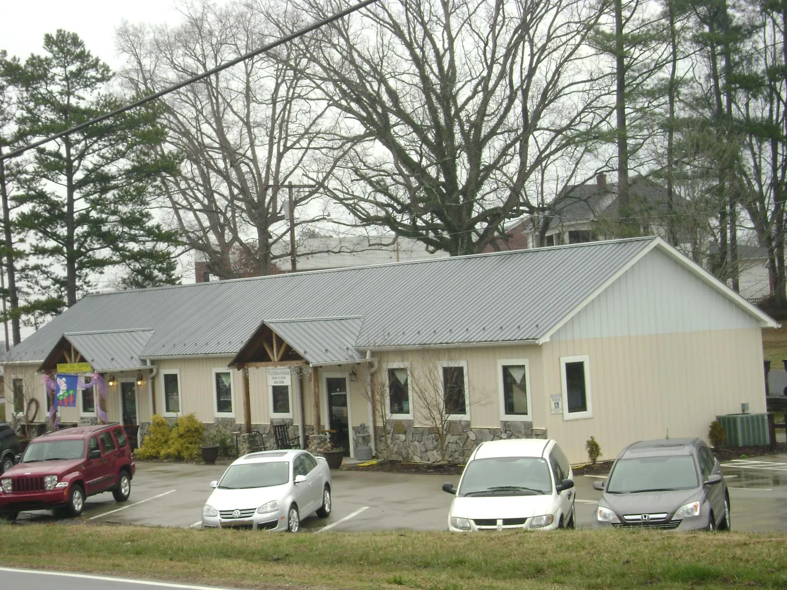 Gray metal roof with timber entry brackets on a small commercial building in Patterson
